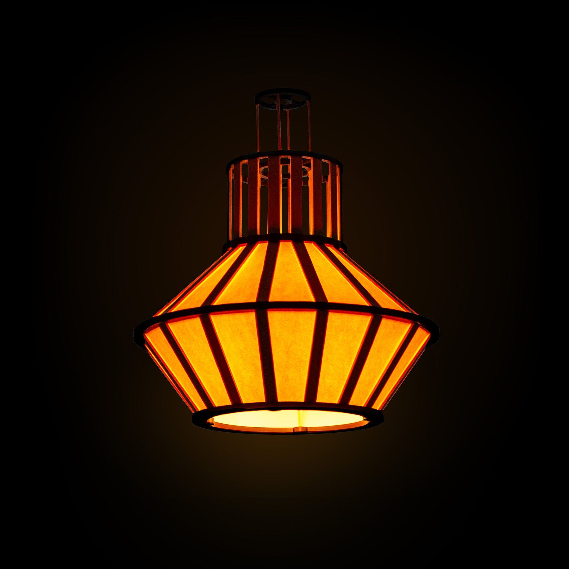 Hängande design-lampskärm i gult med svarta delar och trädetaljer, lyser mot en mörk bakgrund